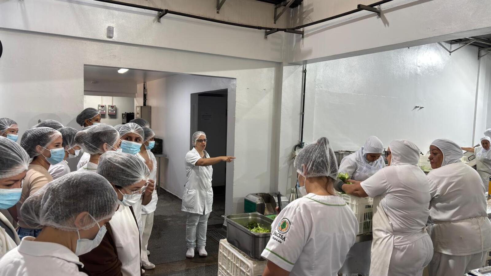Quinze alunos e três professores do curso de nutrição de Salto del Guairá observam o funcionamento e protocolos de produção de alimentos do município